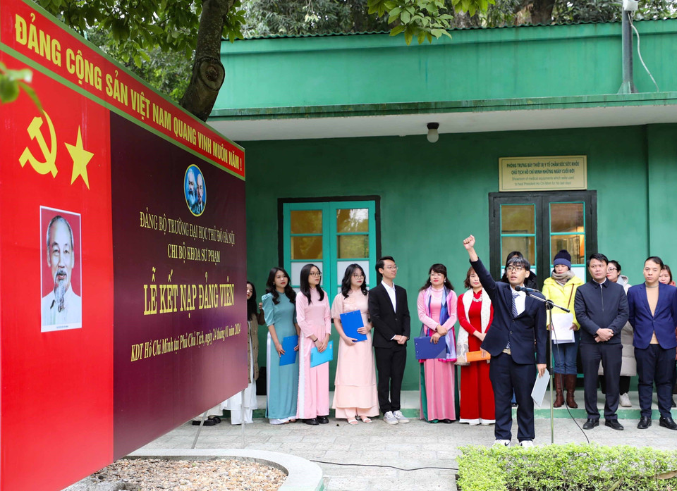 Dưới cờ Đảng, cờ Tổ quốc và chân dung Chủ tịch Hồ Chí Minh, sinh viên ưu tú đọc lời tuyên thệ. (Ảnh: Thanh Tùng/TTXVN)
