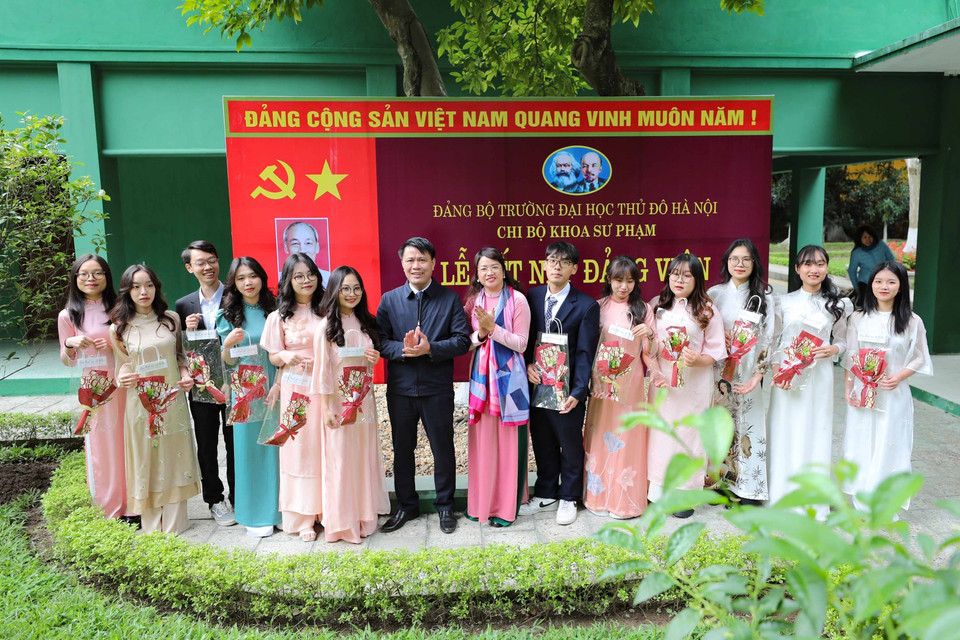 Đồng chí Nguyễn Văn Tuân, Thường Vụ đảng ủy, Phó hiệu trưởng trường Đại học Thủ đô tặng hoa chúc mừng các đảng viên mới. (Ảnh: Thanh Tùng/TTXVN)