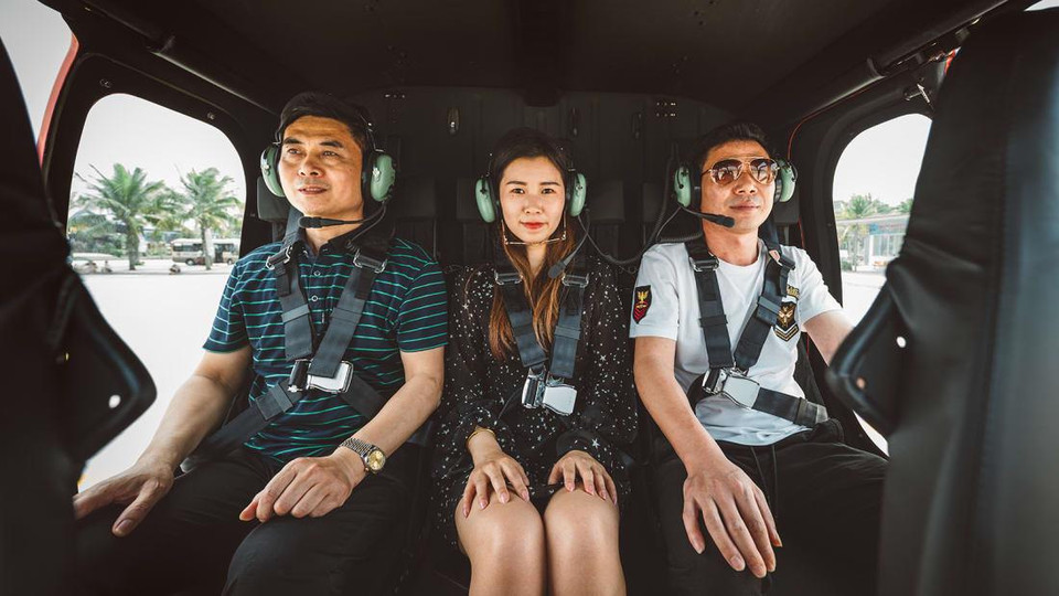 Du khách có thể chụp ảnh lưu niệm cùng phi công, trực thăng và check-in khi bay trên cảnh quan tuyệt đẹp của Hạ Long. (Nguồn: CNN)