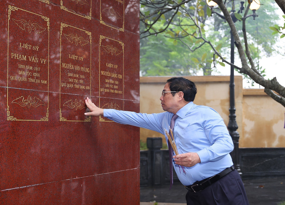Thủ tướng Phạm Minh Chính bên bia ghi danh tưởng nhớ các Anh hùng liệt sỹ tại Khu di tích lịch sử quốc gia Căng-Đồn Nghĩa Lộ. (Ảnh: Dương Giang/TTXVN)