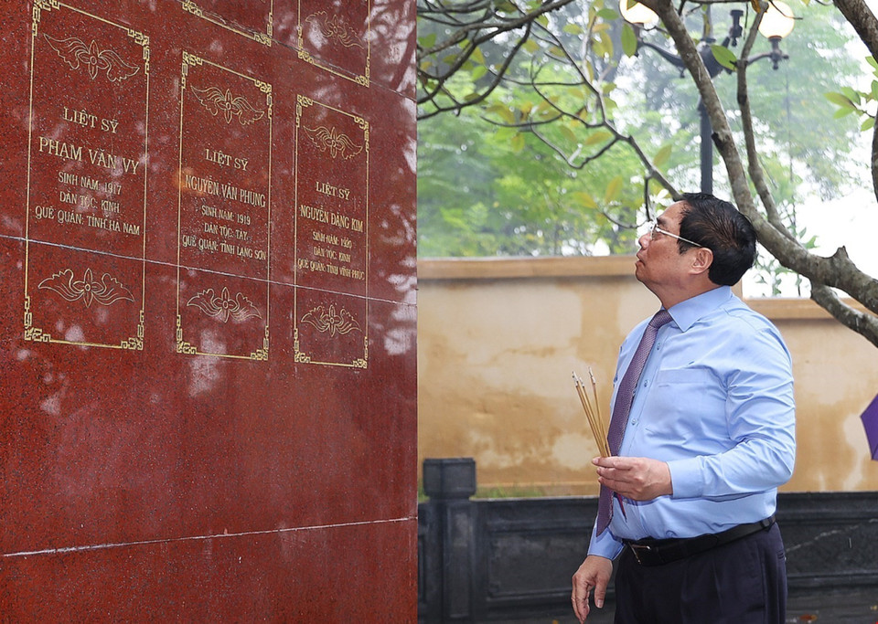 Thủ tướng Phạm Minh Chính xem bia ghi danh tưởng nhớ các Anh hùng liệt sỹ tại Khu di tích lịch sử quốc gia Căng-Đồn Nghĩa Lộ. (Ảnh: Dương Giang/TTXVN)