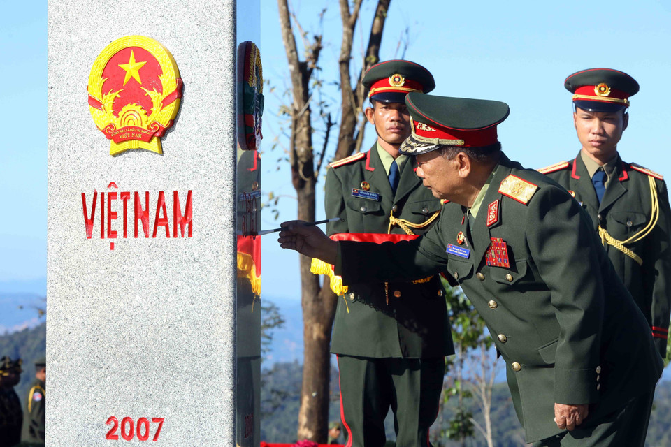 Đại tướng Chansamone Chanyalath, Phó Thủ tướng Chính phủ, Bộ trưởng Bộ Quốc phòng Lào tô son cột mốc chủ quyền tại cột mốc ngã ba biên giới Việt Nam-Lào-Campuchia. (Ảnh: An Đăng/TTXVN)