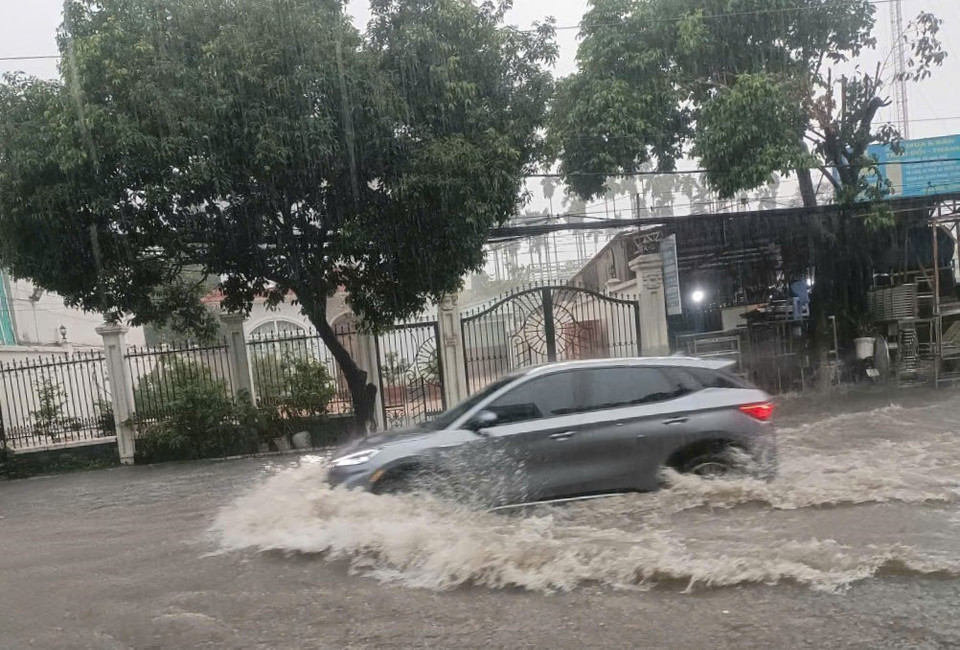 Xe cộ di chuyển khó khăn tại điểm ngập trên đường Cách Mạng Tháng Tám, giáp ranh giữa thành phố Thủ Dầu Một và thành phố Thuận An, tỉnh Bình Dương. (Ảnh: TTXVN phát)