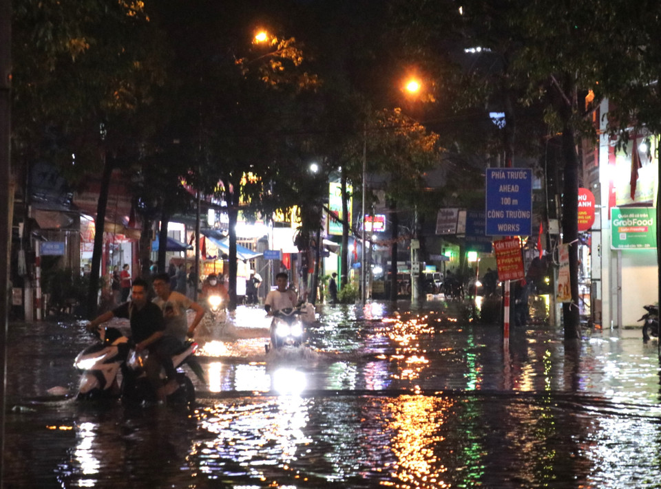 Nước ngập lênh láng khiến con phố sầm uất đường Thích Quảng Đức đảo lộn sinh hoạt. (Ảnh: Dương Chí Tưởng/TTXVN)