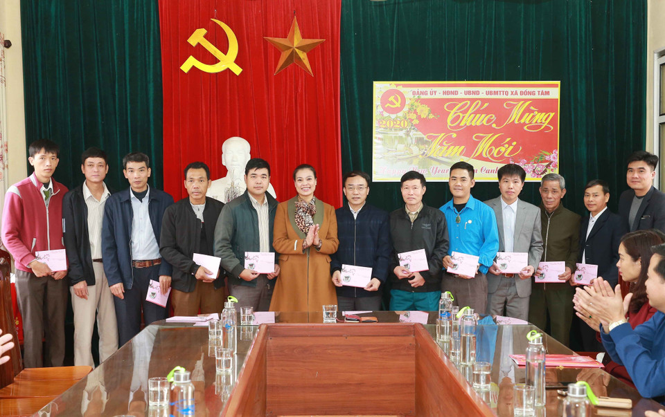 Bà Bạch Liên Hương, Thành ủy viên, Bí thư Huyện ủy huyện Mỹ Đức trao quà Tết cho cán bộ, nhân viên xã Đồng Tâm. (Ảnh: Doãn Tấn/TTXVN)