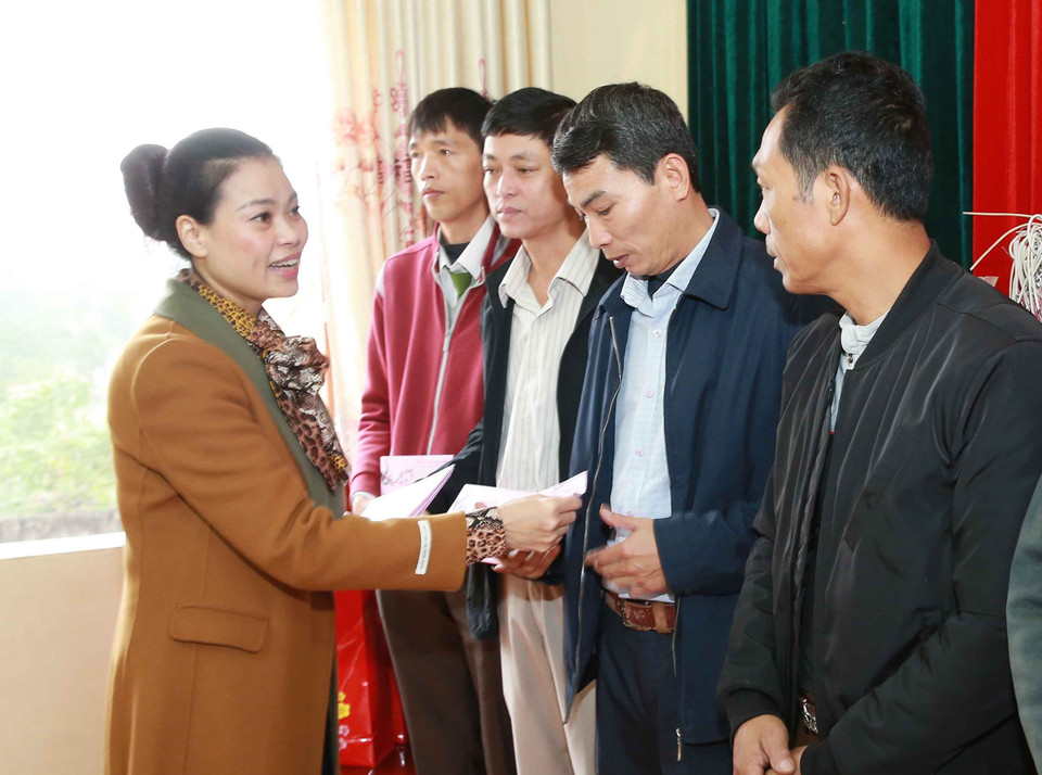 Bà Bạch Liên Hương, Thành ủy viên, Bí thư Huyện ủy huyện Mỹ Đức trao quà Tết cho cán bộ, nhân viên xã Đồng Tâm. (Ảnh: Doãn Tấn/TTXVN)