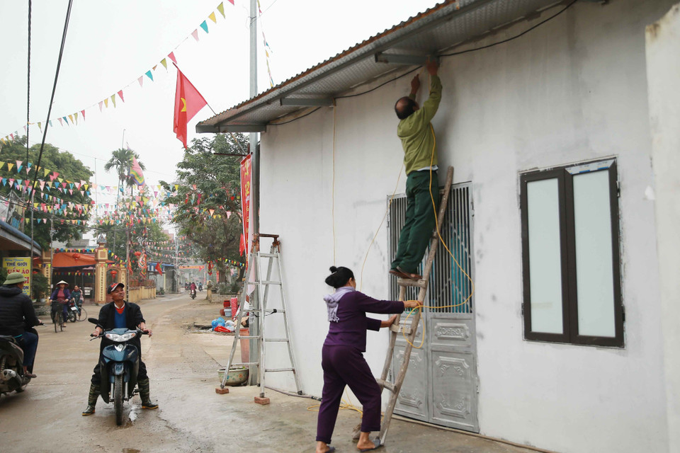 Người dân mắc điện chỉnh trang nhà cửa chuẩn bị đón Tết. (Ảnh: Doãn Tấn/TTXVN)