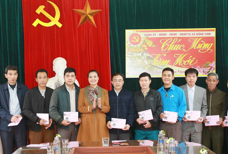 Bà Bạch Liên Hương, Thành ủy viên, Bí thư Huyện ủy huyện Mỹ Đức trao quà Tết cho cán bộ, nhân viên xã Đồng Tâm. (Ảnh: Doãn Tấn/TTXVN)