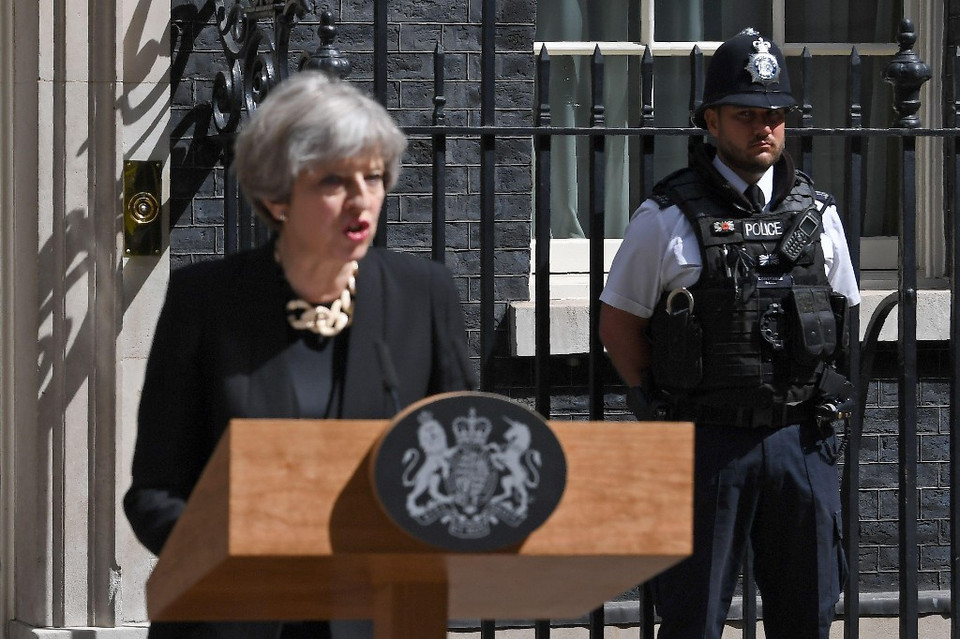 Nhân viên an ninh quan sát xung quanh khi Thủ tướng Anh Theresa May phát biểu. (Nguồn: Getty)