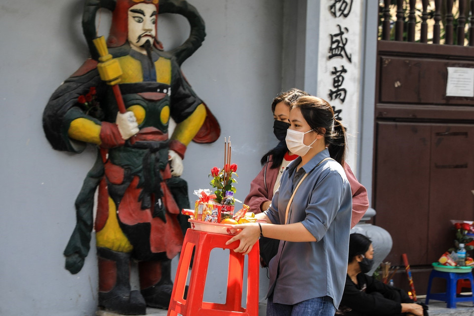 Nhiều bạn trẻ mua đồ lễ đến cầu bình an, cầu duyên trước cổng chùa Hà. (Ảnh: Thành Đạt/TTXVN)