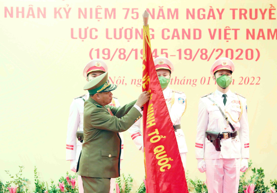 Đại tướng Vilay Lakhamphong, Bộ trưởng Bộ Công an nước Cộng hòa Dân chủ Nhân dân Lào gắn Huân chương Tự do hạng Nhất của Nhà nước CHDCND Lào lên lá cờ truyền thống của Bộ Công an nước CHXHCN Việt Nam. (Ảnh: Phạm Kiên/TTXVN)
