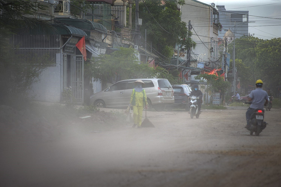 Người dân ngày ngày đi qua đường Hòa Bình nhiều ổ voi, ổ gà đầy bụi trong nỗi lo sợ về an toàn giao thông và sức khỏe. (Ảnh: Trọng Đạt/TTXVN)