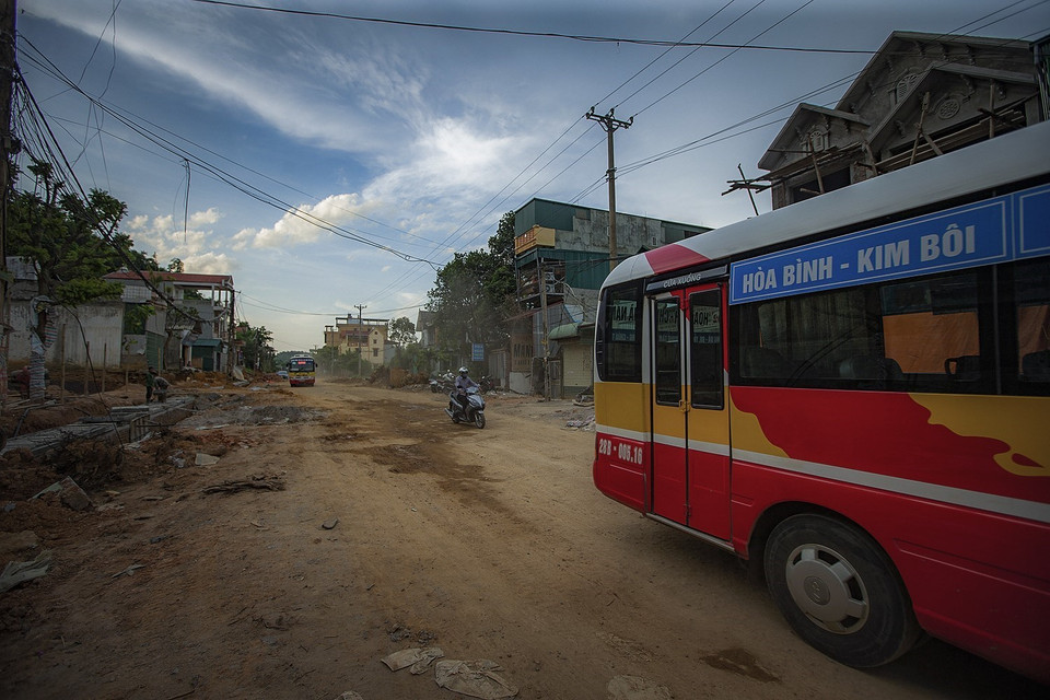 Người dân ngày ngày đi qua đường Hòa Bình nhiều ổ voi, ổ gà đầy bụi trong nỗi lo sợ về an toàn giao thông và sức khỏe. (Ảnh: Trọng Đạt/TTXVN)