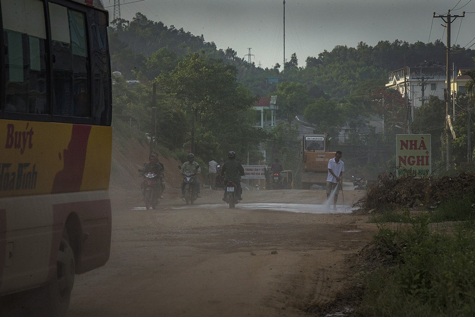 Người dân hàng ngày sáng, trưa, chiều, tối vẫn phải xịt nước ra trước nhà để chống bụi. (Ảnh: Trọng Đạt/TTXVN)