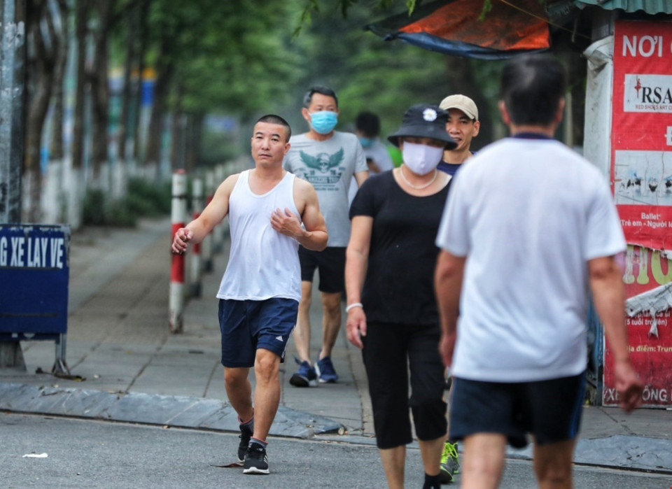 Người dân tập thể dục xung quanh công viên Cầu Giấy bất chấp lệnh cấm, một số người còn chủ quan không đeo khẩu trang phòng chống dịch. (Ảnh: Thành Đạt/TTXVN)