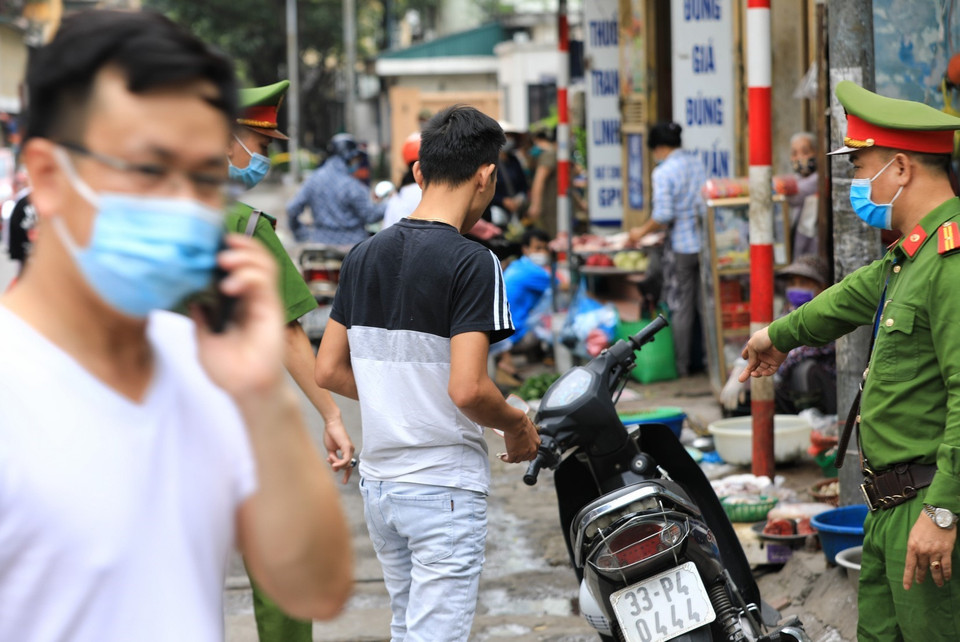 Lực lượng công an phường Phương Mai, Đống Đa, Hà Nội xử phạt vi phạm không đeo khẩu trang nơi công cộng nhằm nâng cao ý thức của người dân. (Ảnh: Thành Đạt/TTXVN)