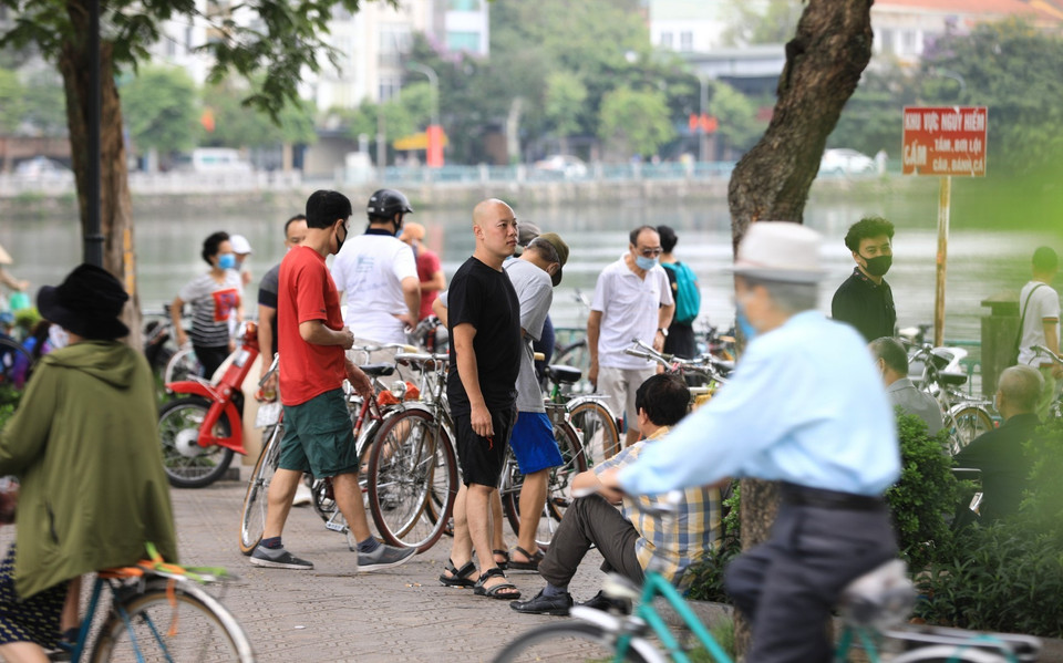Người dân tụ tập đông người, không đeo khẩu trang đúng cách phòng chống dịch tại khu vực hồ Tây. (Ảnh: Thành Đạt/TTXVN)