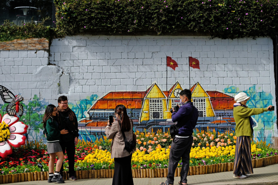 Sự kết hợp độc đáo giữa tranh tường với hình ảnh kiến trúc nổi tiếng của Đà Lạt và muôn sắc hoa Đà Lạt hấp dẫn không ít du khách. (Ảnh: Nguyễn Dũng/TTXVN)