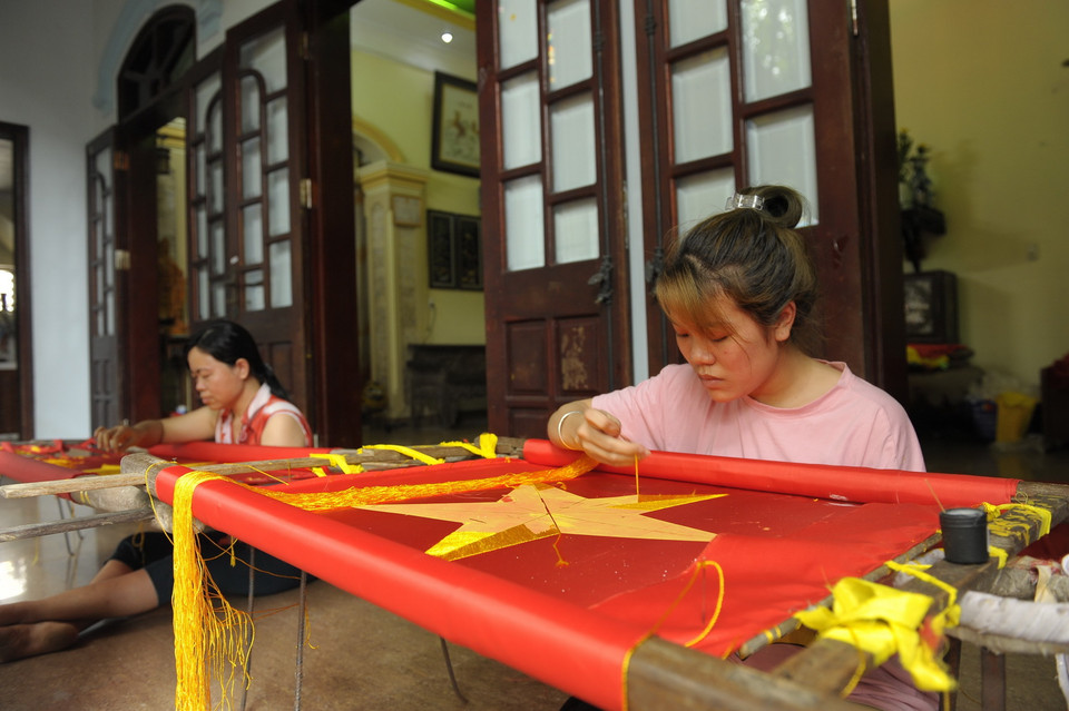 Nghề sản xuất cờ đã có ở Từ Vân cách đây vài chục năm trước. Hiện xã Lê Lợi có khoảng hàng trăm hộ tham gia các công đoạn để làm ra các loại cờ, băngrôn, panô, ápphích...(Ảnh: Mạnh Khánh/TTXVN)