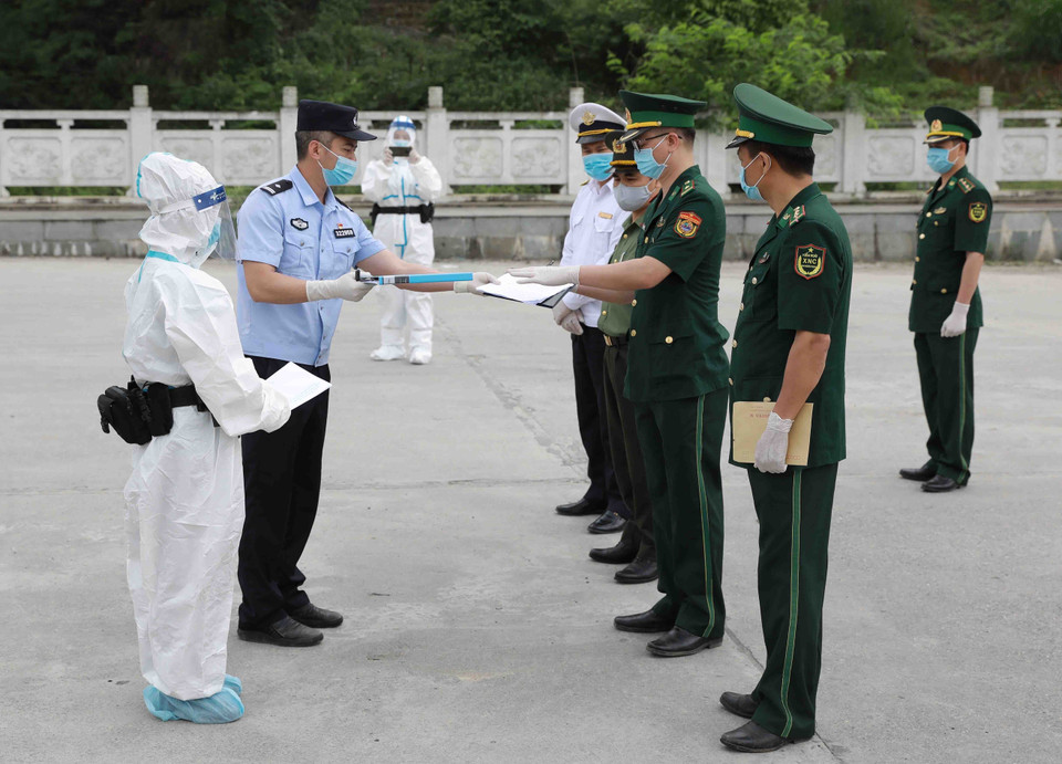 Lực lượng chức năng của 2 bên tiến hành làm các thủ tục bàn giao công dân tại cửa khẩu Trà Lĩnh, huyện Trùng Khánh, tỉnh Cao Bằng. (Ảnh: Vũ Sinh/TTXVN)