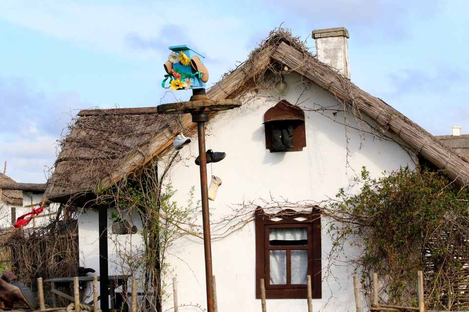 Người thợ sửa giày Cossack quảng cáo bằng cách treo các đôi giày trước nhà để mọi người biết đến. (Ảnh: Duy Trinh/TTXVN)