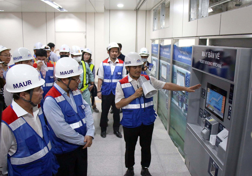 Phó Thủ tướng Phạm Bình Minh (thứ hai từ trái sang) khảo sát trạm bán vé tự động tại tầng hầm ga Nhà hát Thành phố tuyến metro số 1 Bến Thành-Suối Tiên. (Ảnh: TTXVN phát)