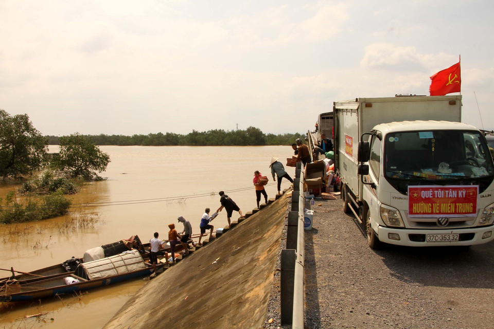 Các đoàn cứu trợ tập trung đưa những mặt hàng thiết yếu đến vùng bị nước lũ cô lập ở các xã của huyện Quảng Ninh, tỉnh Quảng Bình. (Ảnh: Văn Tý/TTXVN)