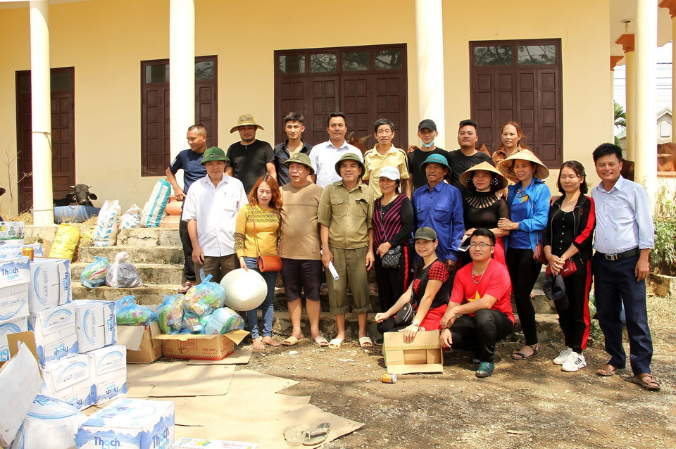 Đoàn cứu trợ đến từ Diễn Châu (Nghệ An) chụp ảnh lưu niệm khi cứu trợ tại xã Võ Ninh, huyện Quảng Ninh, tỉnh Quảng Bình. (Ảnh: Văn Tý/TTXVN)