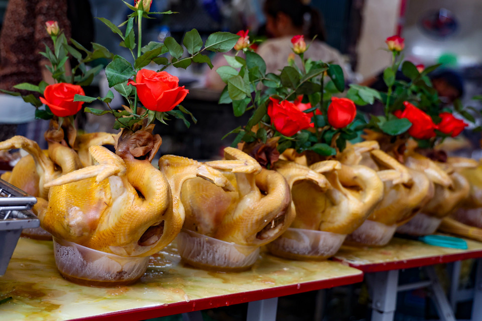 Gà ngậm hoa hồng tại chợ Hàng Bè (quận Hoàn Kiếm, Hà Nội) dù đắt đỏ nhưng vẫn hút khách, giá dao động 350.000-500.000 đồng/con. (Ảnh: Minh Hiếu/Vietnam+)