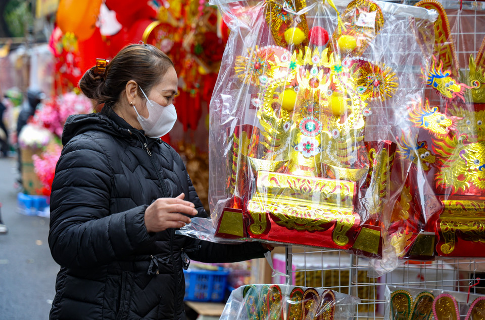 Bà Hương, tiểu thương bán vàng mã tại Hàng Mã (quận Hoàn Kiếm, Hà Nội) cho biết gần ông Công ông Táo sức mua mặt này có tăng cao, tuy nhiên sức mua giảm khoảng 10-20% so với năm ngoái. (Ảnh: Minh Hiếu/Vietnam+)