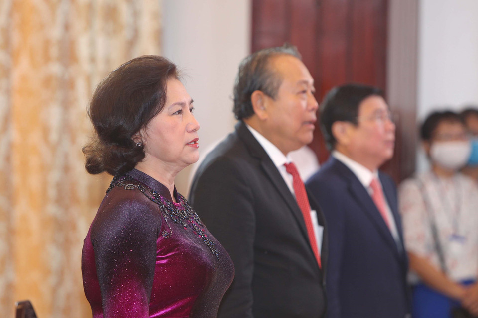 Chủ tịch Quốc hội Nguyễn Thị Kim Ngân, Phó Thủ tướng Thường trực Trương Hòa Bình thực hiện nghi thức chào cờ tại lễ kỷ niệm. (Ảnh: Thanh Vũ/TTXVN)