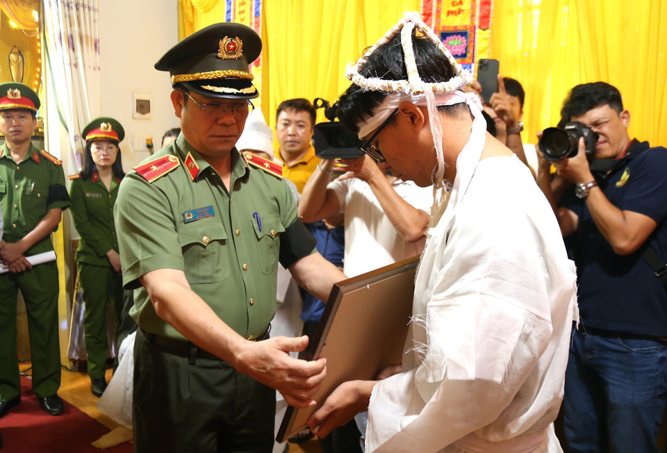 Thiếu tướng Lê Vinh Quy, Giám đốc Công an tỉnh Đắk Lắk trao Bằng Tổ quốc ghi công cho gia đình Thiếu tá Hoàng Trung, cán bộ Công an xã Ea Ktur, huyện Cư Kuin. (Ảnh: Quang Thái/TTXVN)