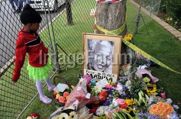 Một cháu bé đứng trước di ảnh của cố Tổng thống Nam Phi Nelson Mandela. (Nguồn: AFP)