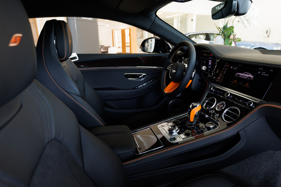 Nội thất của chiếc Continental GT S này mang dấu ấn đặc trưng của Mulliner tôn vinh tính cá nhân hóa của Bentley. Sắc cam Mandarin nổi bật ở cần số và vô lăng đồng thời điểm xuyết tinh tế ở các chi tiết viền chỉ thêu, logo thêu trên ghế ngồi, tạo sự tương phản. (Ảnh nguồn: Bentley) 