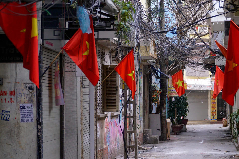 Những lá cờ đỏ sao vàng len lỏi trong cả những con ngõ. Việc treo cờ Tổ quốc vào mỗi dịp trọng đại của đất nước góp phần thể hiện niềm tự hào về những năm tháng chiến đấu, hy sinh của toàn dân để giành lại độc lập dân tộc, toàn vẹn lãnh thổ. (Ảnh: Minh Hiếu/Vietnam+)