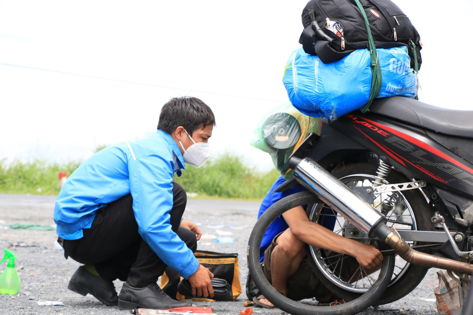 Lực lượng SOS của thanh niên huyện Tháp Mười, tỉnh Đồng Tháp hỗ trợ sửa chữa xe máy miễn phí 24/24 cho người dân trên đường về quê. (Ảnh: Chương Đài/TTXVN)