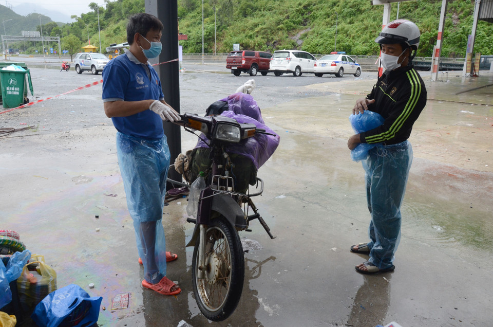 Anh Phan Thanh Tin, đại diện Nhóm thiện nguyện Bánh mì 0 đồng Đà Nẵng (bên trái) kiểm tra xe anh Nguyễn Quang Bình (bên phải) và cho biết sẽ tặng một chiếc xe máy mới. (Ảnh: Quốc Dũng/TTXVN)