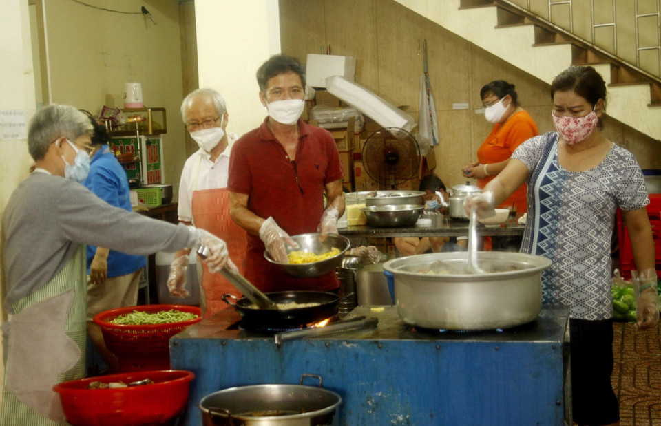 Cán bộ, nhân viên Ủy ban Nhân dân phường Thống Nhất, thành phố Buôn Ma Thuột nấu cơm để phát cho người dân về quê. (Ảnh: TTXVN phát)