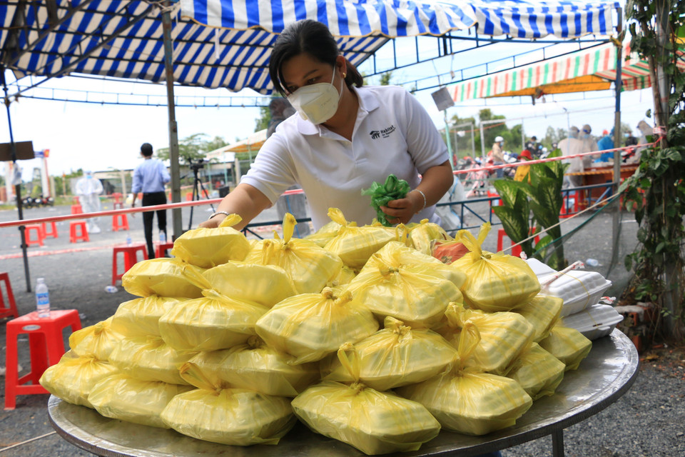 Phụ nữ huyện Tháp Mười, tỉnh Đồng Tháp chuẩn bị các suất ăn miễn phí để kịp thời hỗ trợ cho người dân khi về đến điểm tiếp nhận trên Quốc lộ N2 (đoạn thuộc xã Đốc Binh Kiều, huyện Tháp Mười, tỉnh Đồng Tháp). (Ảnh: Chương Đài/TTXVN)
