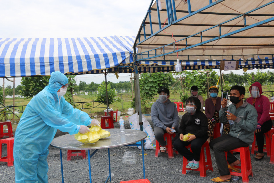 Huyện Tháp Mười, tỉnh Đồng Tháp hỗ trợ người dân các suất ăn miễn phí tại điểm tiếp nhận trên Quốc lộ N2 (đoạn thuộc xã Đốc Binh Kiều, huyện Tháp Mười, tỉnh Đồng Tháp). (Ảnh: Chương Đài/TTXVN)