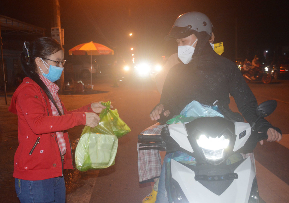 Người dân về quê đi ngang tỉnh Đắk Lắk được hỗ trợ các phần cơm và nước uống. (Ảnh: Hoài Thu/TTXVN)