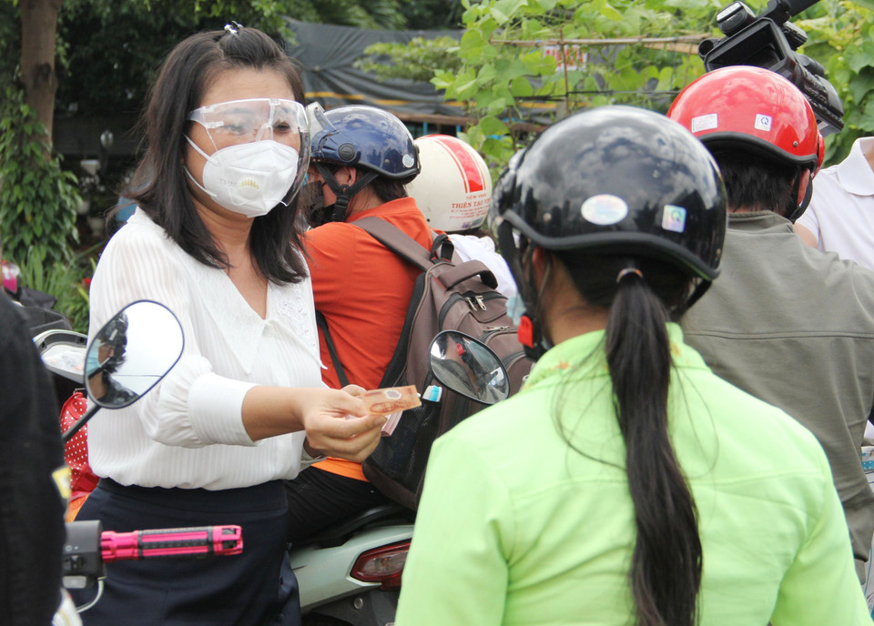 Phó Chủ tịch UBND tỉnh Đắk Lắk H’Yim Kđoh hỗ trợ tiền xăng cho người dân về quê. (Ảnh: TTXVN phát)