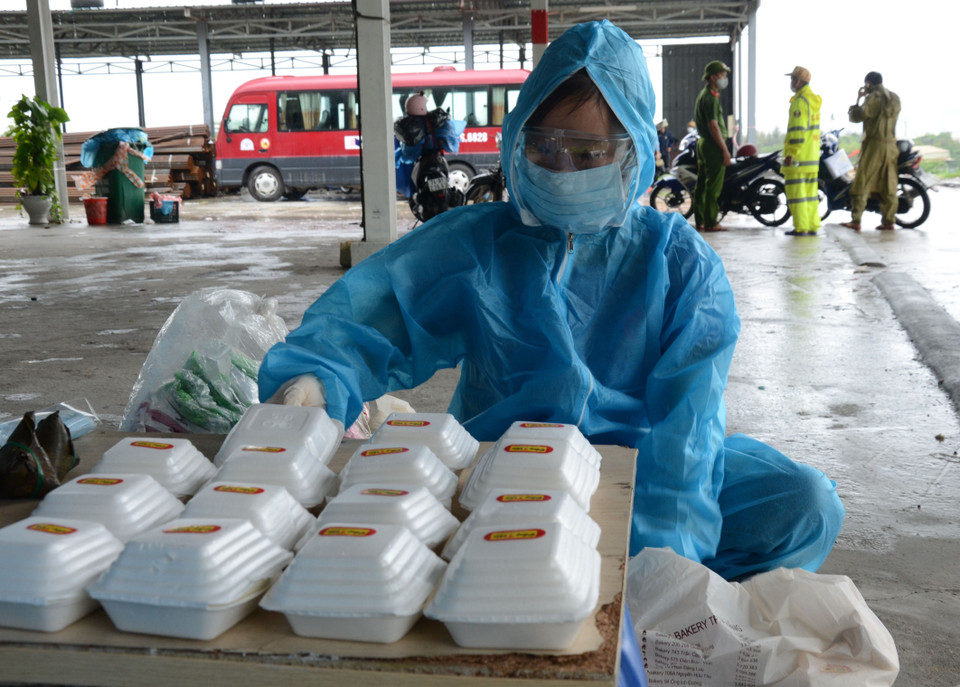 Tình nguyện viên cẩn thận sắp xếp những phần ăn nóng hổi để đón đoàn người về quê. (Ảnh: Quốc Dũng/TTXVN)