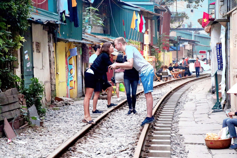 Du khách người nước ngoài còn bày tỏ tình cảm ngay trên đường ray tàu hỏa. (Ảnh: Vi Thương-Hải Yến/TTXVN)
