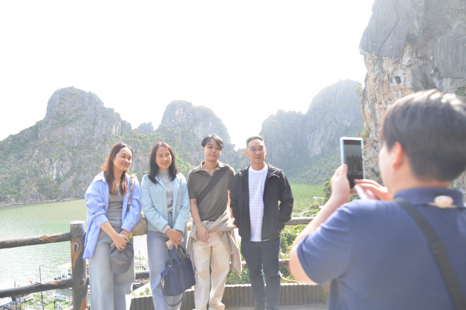 Du khách quốc tế thích thú chụp ảnh trong hành trình tham quan vịnh Hạ Long. (Ảnh: Thanh Vân/TTXVN)