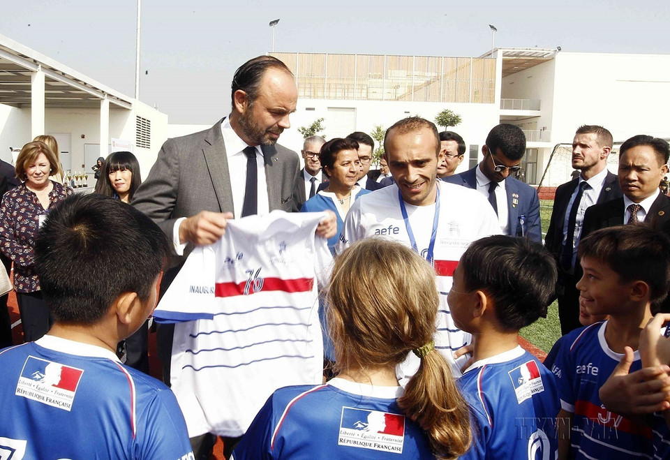 Học sinh Trường Quốc tế Pháp Alexandre Yersin (quận Long Biên, Hà Nội) tặng Thủ tướng Pháp Édouard Philippe chiếc áo thể thao nhân dịp Thủ tướng đến thăm và cắt băng khánh thành trường ngày 3/11/2018. (Ảnh: Văn Điệp/TTXVN)