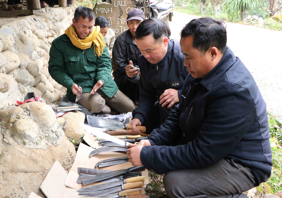 Cánh đàn ông lựa chọn mua dao, rựa dùng cho công việc. (Ảnh: Nguyễn Oanh/TTXVN)