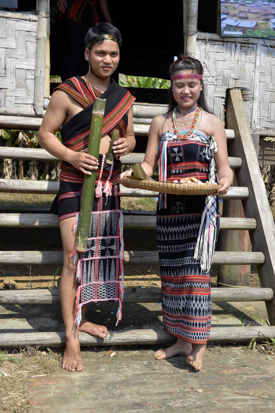 Cô dâu chú rể mang rượu thịt đi mời mọi người tới dự. (Ảnh: TTXVN)