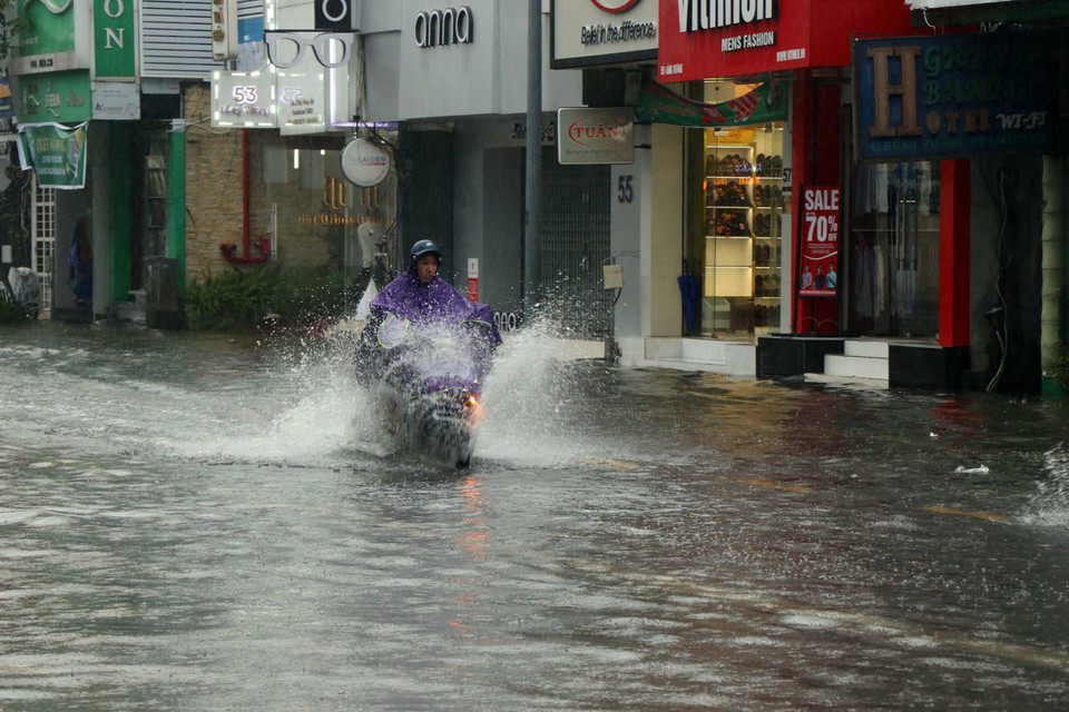 Nước ngập tại nhiều tuyến đường trong thành phố Huế khiến việc đi lại khó khăn. (Ảnh: Đỗ Trưởng/TTXVN)