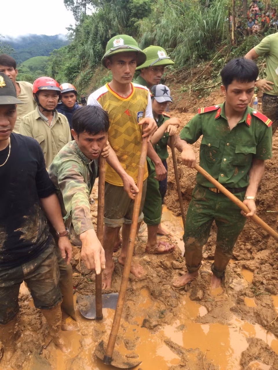 Lực lượng chức năng và người dân tìm kiếm nạn nhân bị vùi lấp do sạt lở núi ở thôn Tà Rùng, xã Húc, huyện Hướng Hóa. (Ảnh: TTXVN phát)